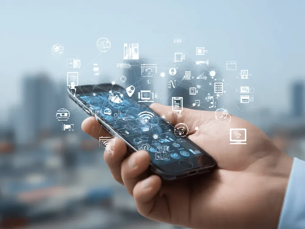 Hand holding smartphone with floating IoT and cloud icons illustrating connected devices and services